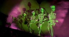 three skeletons are dancing in the dark