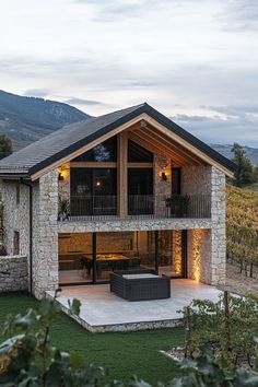 a stone house with an outdoor hot tub in the front yard and patio area next to it