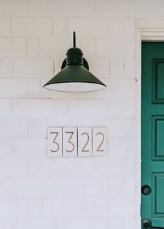 a green front door with the number 5322 on it next to a white brick building