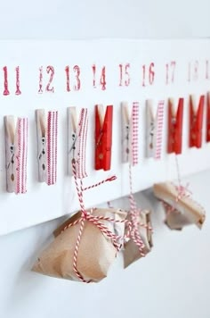 some clothes pins are hanging on a white board with red and white striped twine