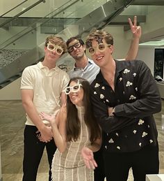 four people posing for a photo in front of an escalator