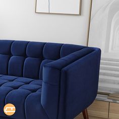 a blue couch sitting on top of a hard wood floor next to a white wall