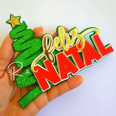 a hand holding a green and gold merry naal sticker in front of a white background