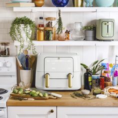 the kitchen counter is cluttered with pots, knives, and other household items on it