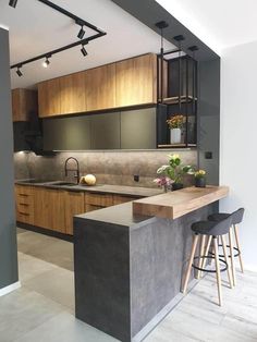 a kitchen with an island counter and stools next to the sink, cabinets and counters