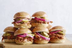 a pile of sandwiches sitting on top of a cutting board