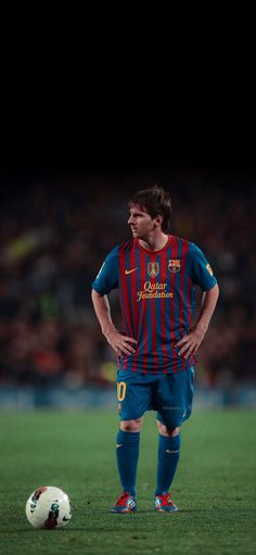 a man standing next to a soccer ball on a field