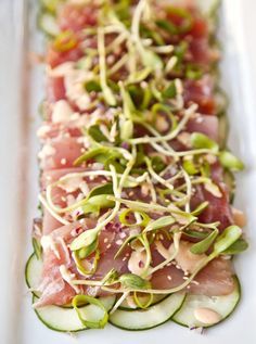 a white plate topped with cucumber and tuna