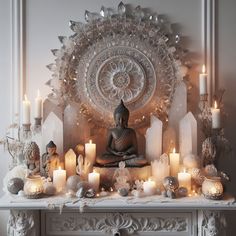 a buddha statue sitting on top of a table surrounded by candles and other decor items