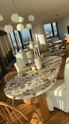 a dining room table and chairs in front of a large window with cityscape on it