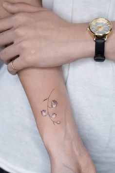 a woman's arm with a small tattoo on it