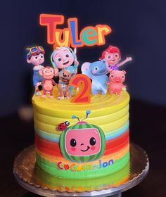 a birthday cake decorated with cartoon characters and the words tuler on top is lit up