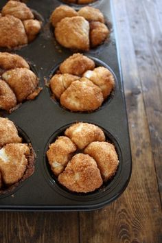 a muffin tin filled with baked goods on top of a wooden table