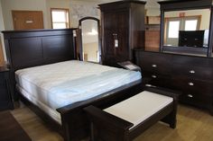 a bedroom with a bed, dresser and mirror