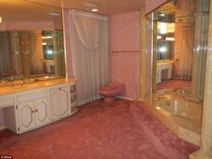 the bathroom has pink carpet and gold trim on the walls, along with an oval bathtub