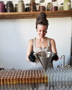 a woman is pouring some liquid into a funnell