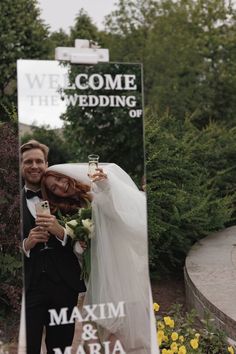 a bride and groom taking a selfie in front of a mirror with the words welcome to the wedding on it