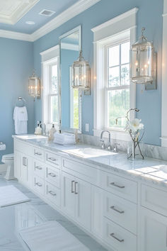 a large bathroom with two sinks, mirrors and lights on the wall in front of them