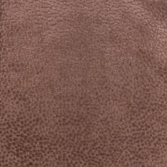 a close up view of a brown leather textured material with small circles on the surface