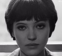 a black and white photo of a woman with short hair wearing a collared shirt