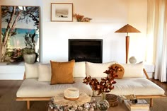 a living room filled with furniture and a fire place next to a wall mounted painting