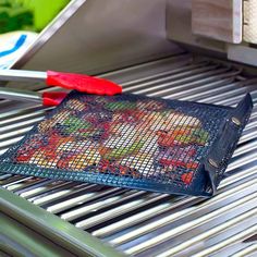 a grill that has some food on it and two red handled tongs next to it