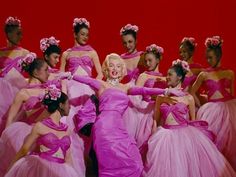 a group of women dressed in pink dresses