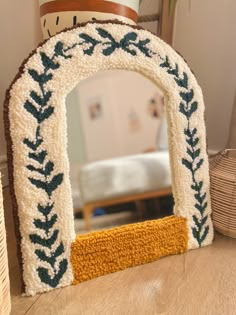 a decorative mirror sitting on top of a wooden table next to a potted plant