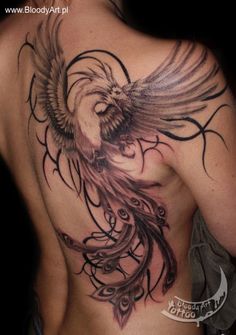 the back of a man's chest with an eagle and swirls tattoo on it