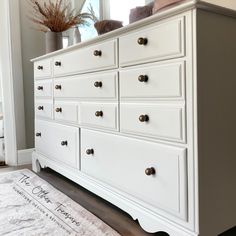 a white dresser with lots of drawers on top of it