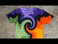 an orange, purple and green t - shirt with a spiral design