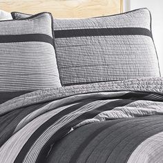 the comforter is made up with black and white striped sheets, along with matching pillows