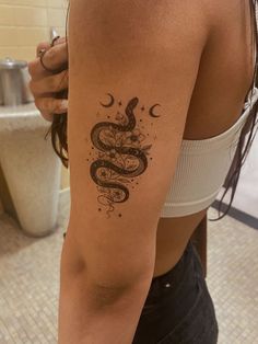 a woman's arm with a snake tattoo on the left side of her body