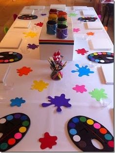 the table is set up with colorful paintbrushes