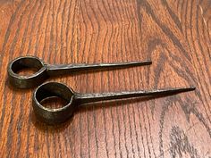 two pairs of scissors sitting on top of a wooden table