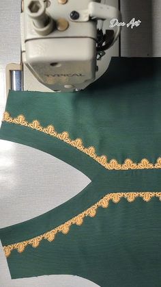 the machine is working on the green and gold material that has been stitched together