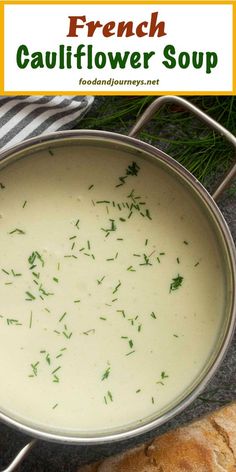 a pot filled with soup sitting on top of a table next to bread and napkin