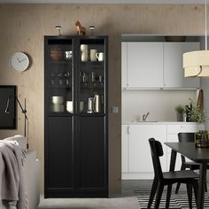 a dining room table and chairs in front of a tall cabinet with glass doors on it