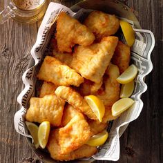 a bowl filled with fried fish and lemon wedges