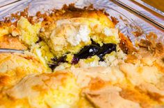 blueberry cobbler in a glass dish with a fork and serving utensil