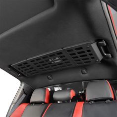 the interior of a car with red and black seats on it's back end