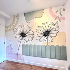 an empty room with flowers painted on the wall and wooden floors in front of it