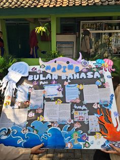 two people holding up a sign with an ocean theme on it that says sulan mahasa