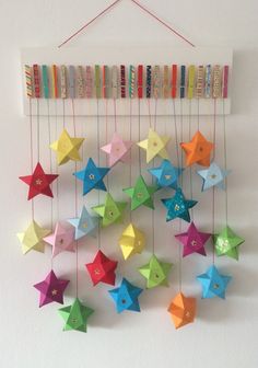 colorful paper stars are hanging on the wall