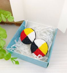 two colorful beaded earrings in a box