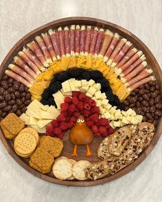 a turkey shaped platter filled with crackers, cheeses, nuts and fruit