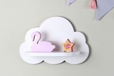 a white shelf with a pink swan and star on it next to a paper cutout