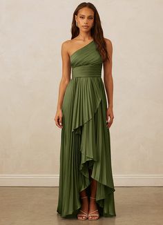 a woman wearing a green dress with one shoulder draped over the top and an asymmetrical skirt