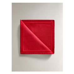 a red napkin folded on top of a white wall