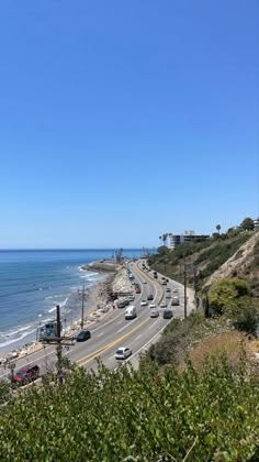 cars are driving down the road by the beach and ocean in california, united states